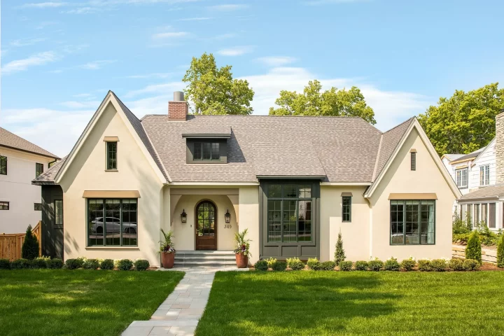 Tudor style custom home near Mississippi River Boulevard in St Paul with cream exterior, dark window accents, and arched front entry